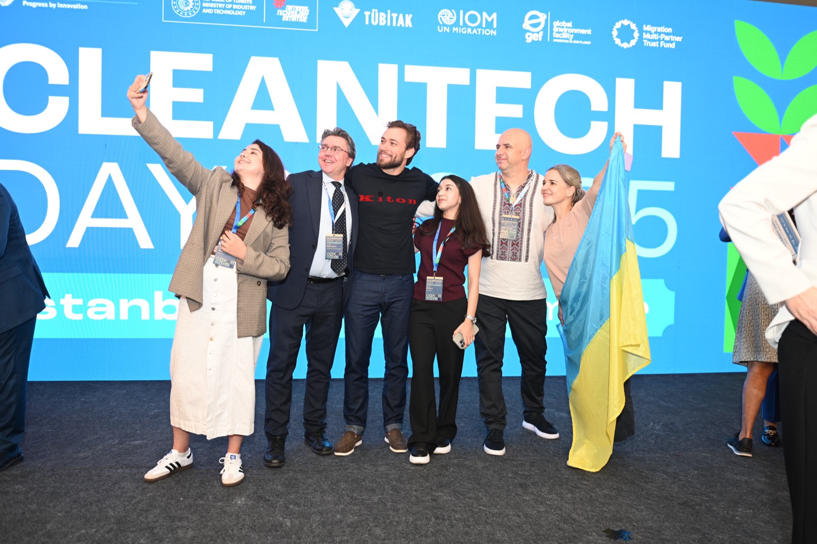 Учасники роблять селфі з українським прапором біля банера Cleantech Days