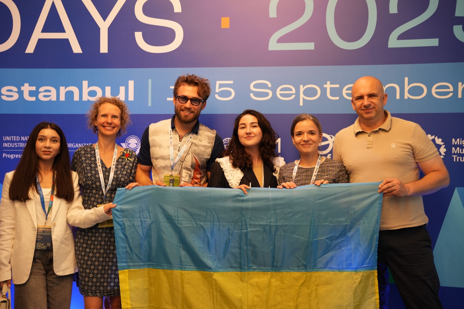 Українська команда з прапором на фоні банера UNIDO Cleantech Days 2025